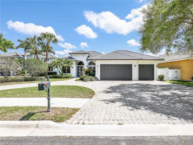 Mediterranean / spanish-style house with curved driveway, stucco siding, a garage, a gate, and a tiled roof