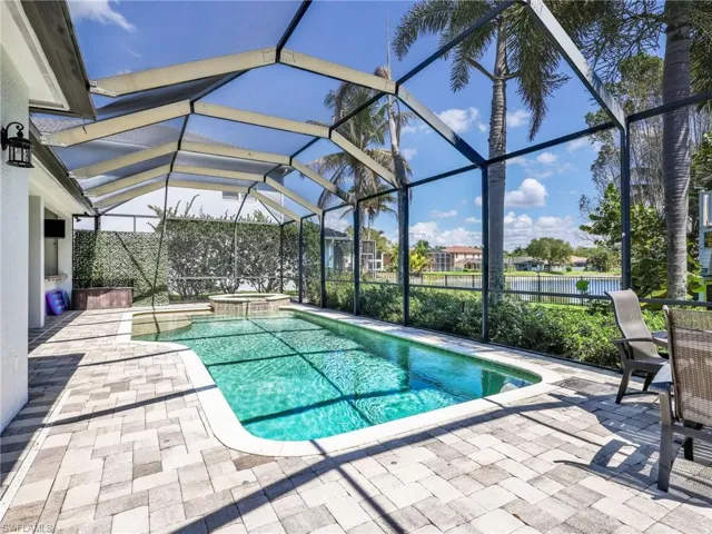 Relaxing pool / spa with a sunroom, a patio area, and a lanai