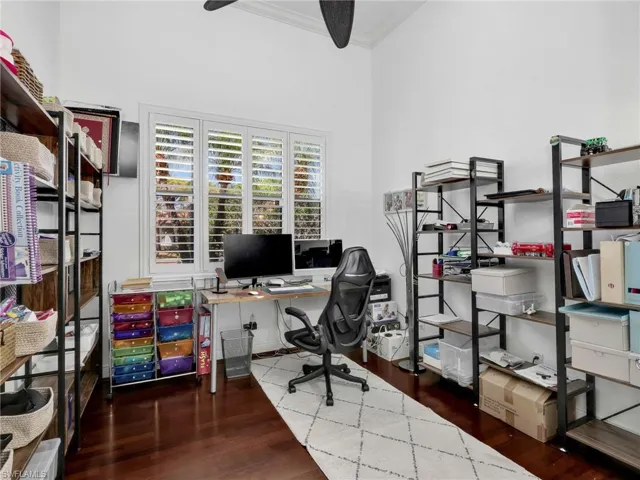 Office with dark wood-style flooring and ornamental molding