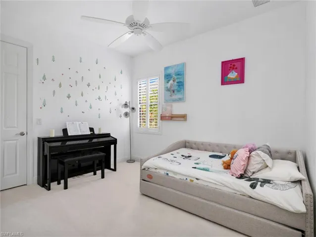 Carpeted bedroom with ceiling fan and baseboards