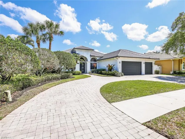 Mediterranean / spanish-style house featuring curved driveway, stucco siding, a front lawn, and a garage