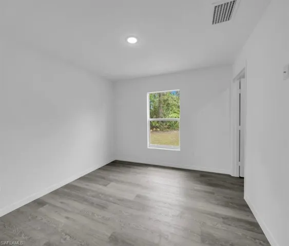 Empty room with light wood-style floors and baseboards