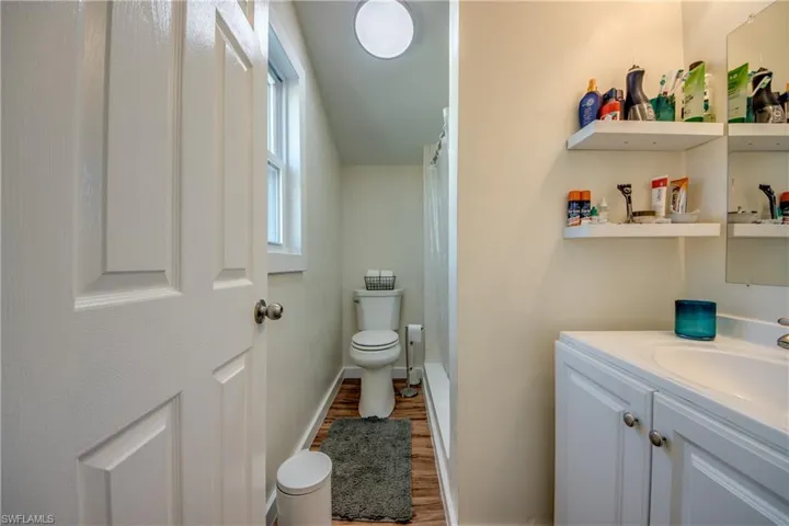 Full bathroom featuring a shower with curtain, vanity, and light wood finished floors