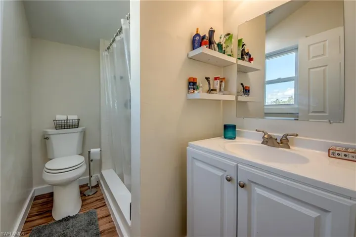 Bathroom featuring vanity, curtained shower, and light wood finished floors