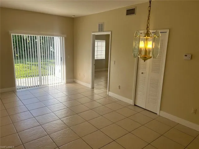 Unfurnished dining area with light tile patterned floors and baseboards
