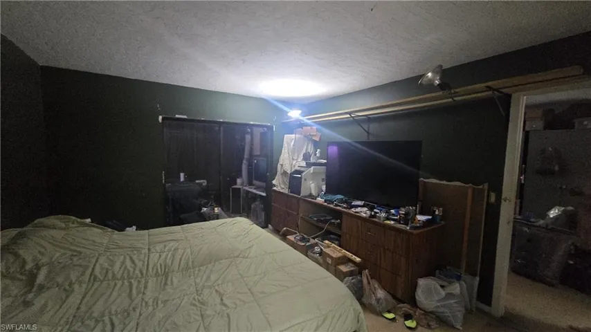 Bedroom with a textured ceiling and a closet