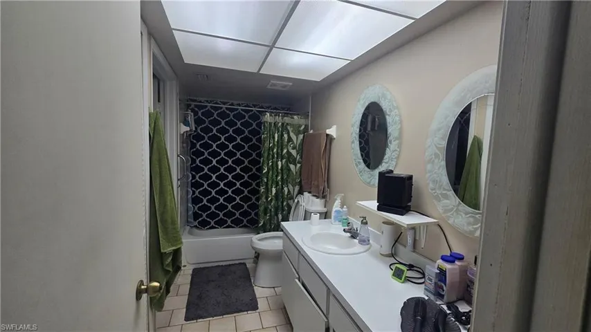 Full bathroom featuring shower / tub combo, vanity, and light tile patterned floors