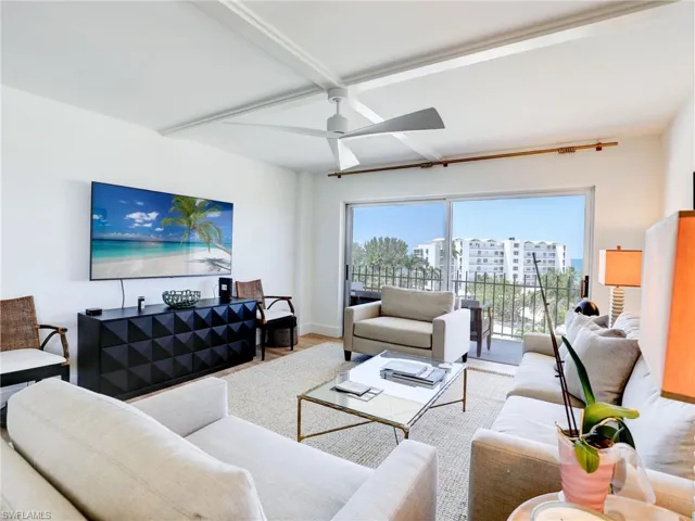 Living room featuring beam ceiling, hardwood / wood-style flooring, and ceiling fan