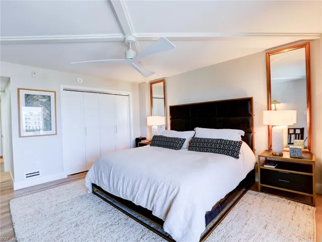 Bedroom featuring hardwood / wood-style flooring, vaulted ceiling, coffered ceiling, and ceiling fan