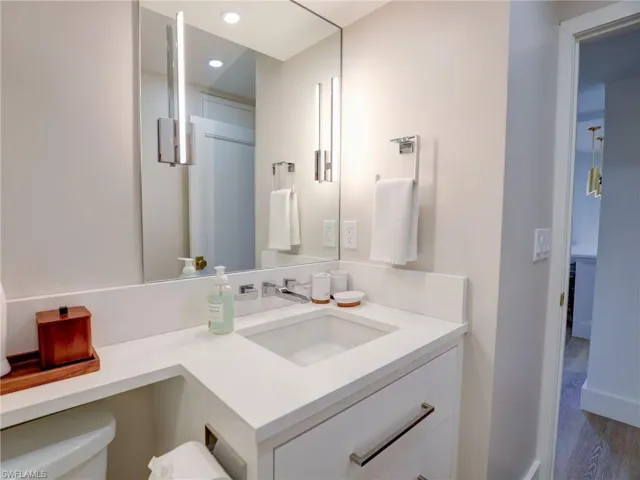 Bathroom with hardwood / wood-style flooring, toilet, and vanity