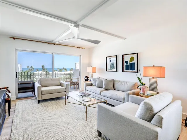 Living room with beamed ceiling, light hardwood / wood-style flooring, and ceiling fan