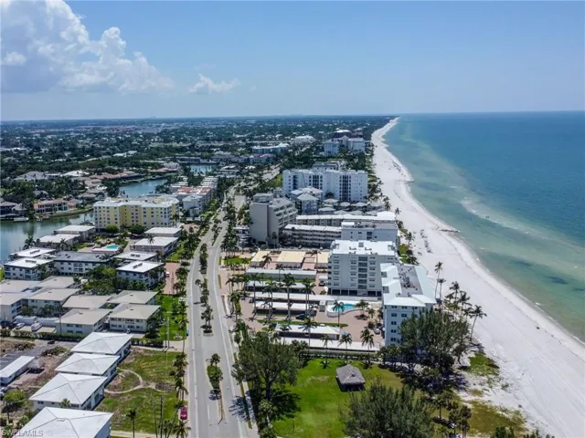 Birds eye view of property featuring a water view and a beach view