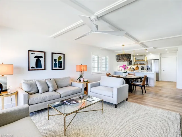 Living room with beamed ceiling and light wood-type flooring