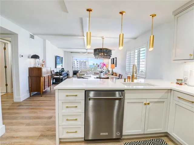 Kitchen featuring dishwasher, light hardwood / wood-style floors, sink, and kitchen peninsula