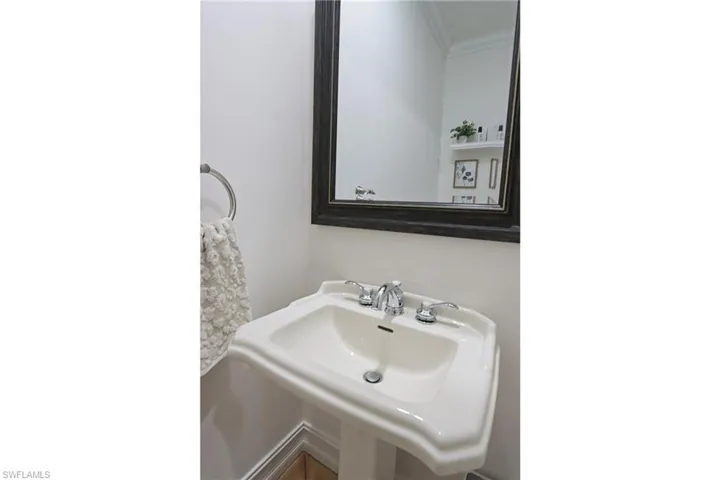 Bathroom with ornamental molding and a sink