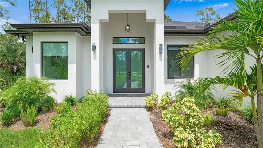 View of exterior entry featuring stucco siding and french doors