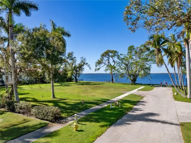 Surrounding community with a water view and a yard
