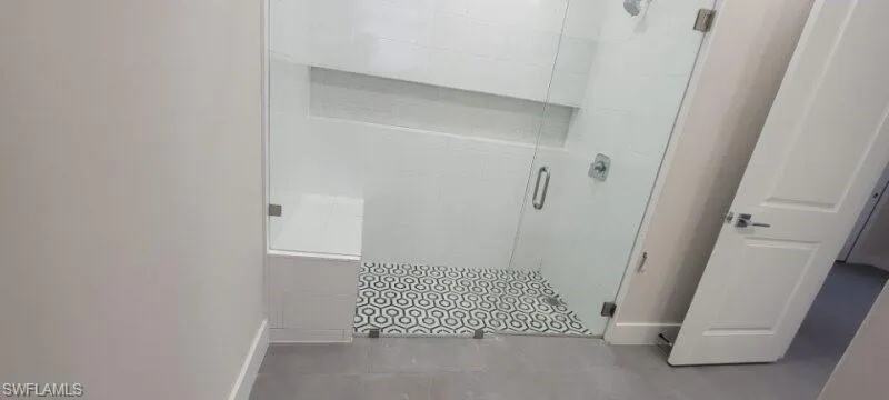 Full bathroom featuring baseboards, a stall shower, and tile patterned flooring
