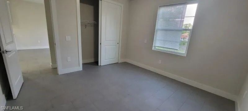 Unfurnished bedroom featuring baseboards and a closet