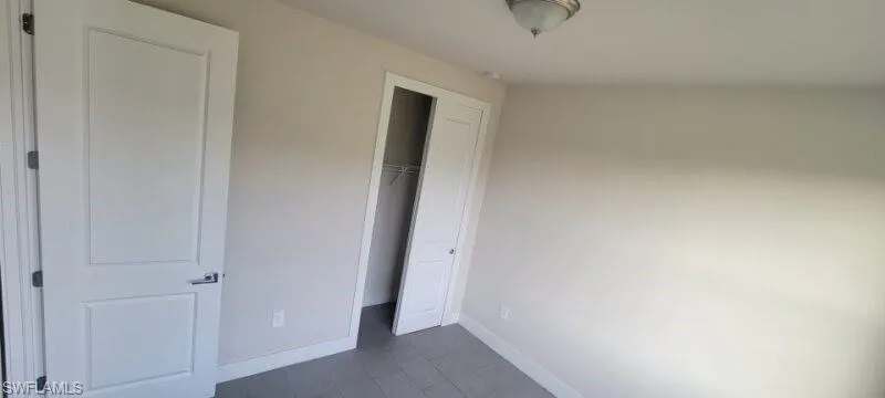 Unfurnished bedroom featuring baseboards and a closet