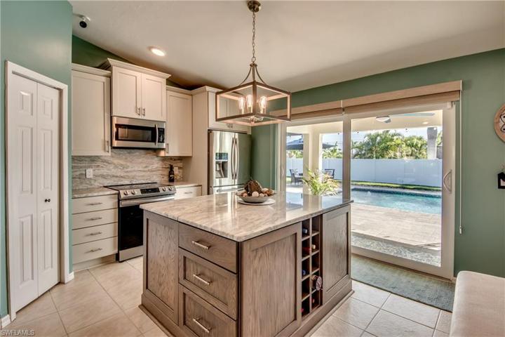 Double hurricane impact sliders open from the kitchen to the outside lanai and paved pool area!