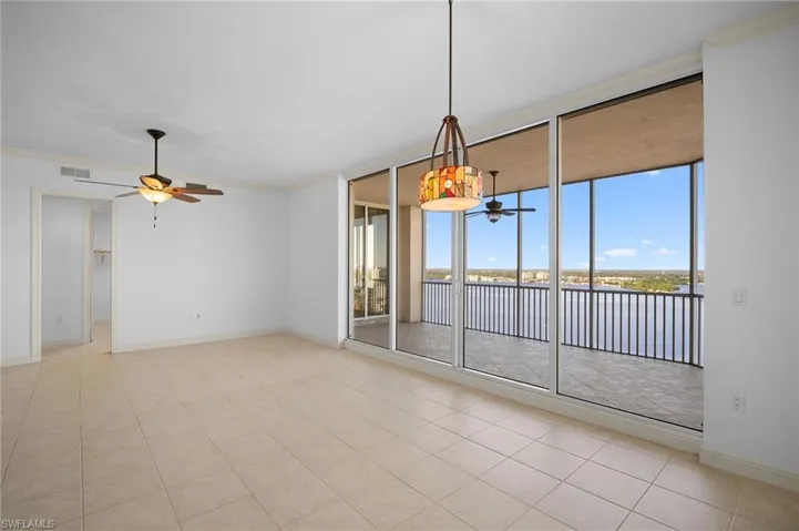 Empty room with ornamental molding, floor to ceiling windows, ceiling fan, a water view, and light tile patterned flooring
