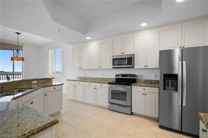 Kitchen with stainless steel appliances, recessed lighting, light tile patterned flooring, pendant lighting, and ornamental molding