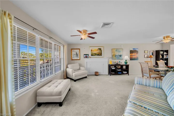 Living area featuring light-colored carpeting and white baseboards