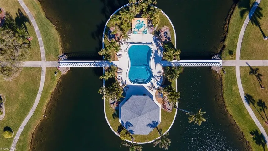 Centrally located island amenity area featuring a freeform swimming pool, shaded gazebo, and surrounding palm trees