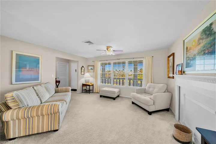 Expansive living area featuring light-colored carpeting and neutral wall tones