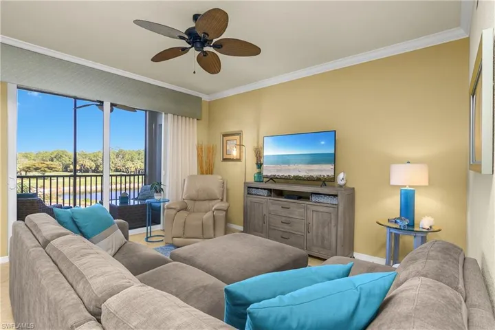 Living area featuring crown molding and a ceiling fan