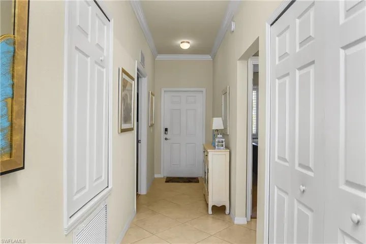 Corridor featuring crown molding and light tile diagonal floors