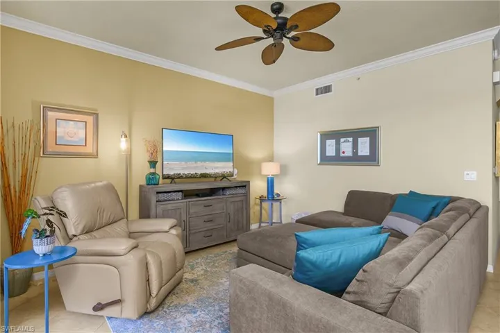 Living room with crown molding and ceiling fan