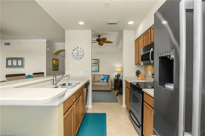 Kitchen with stainless steel appliances, light countertops, and light tile patterned floors