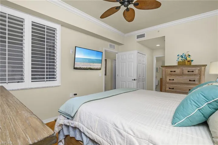 Primary Bedroom featuring ornamental molding, a ceiling fan, bamboo wood finished floors, and a closet