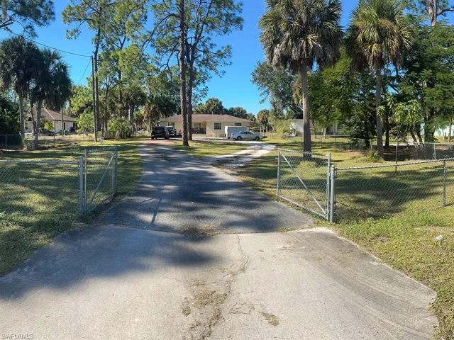 View of asphalt driveway with a gated entry and a gate