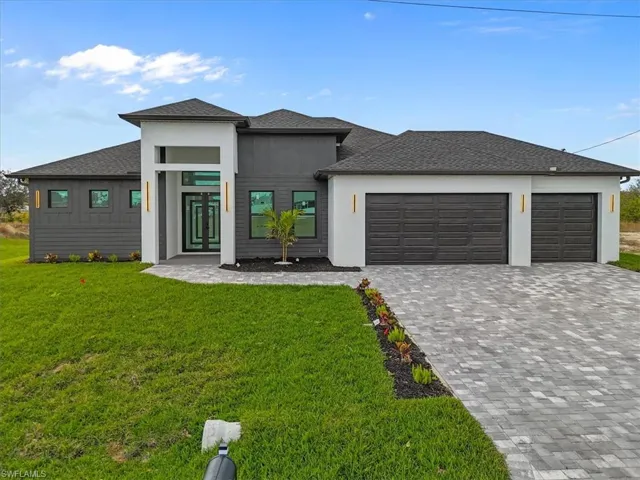 Prairie-style home with roof with shingles, an attached garage, decorative driveway, and a front lawn