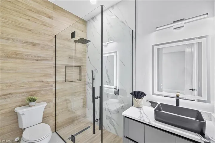 Full bathroom featuring vanity and a marble finish shower
