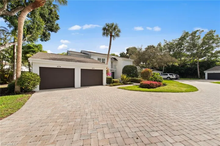 View of front of house with an attached garage, decorative driveway, and stucco siding