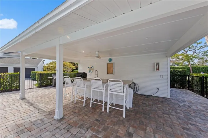View of patio featuring exterior bar, ceiling fan, and grilling area