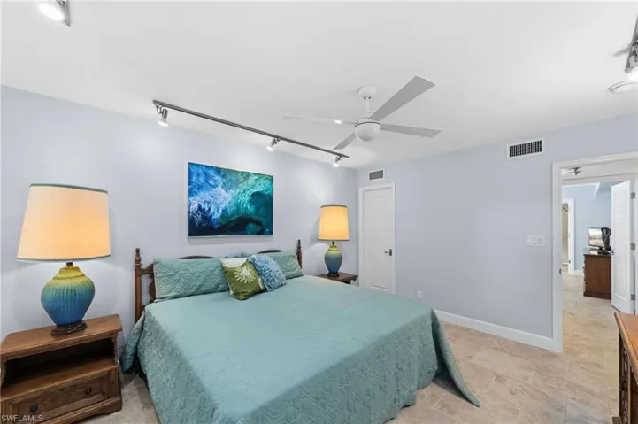 Bedroom with rail lighting and ceiling fan