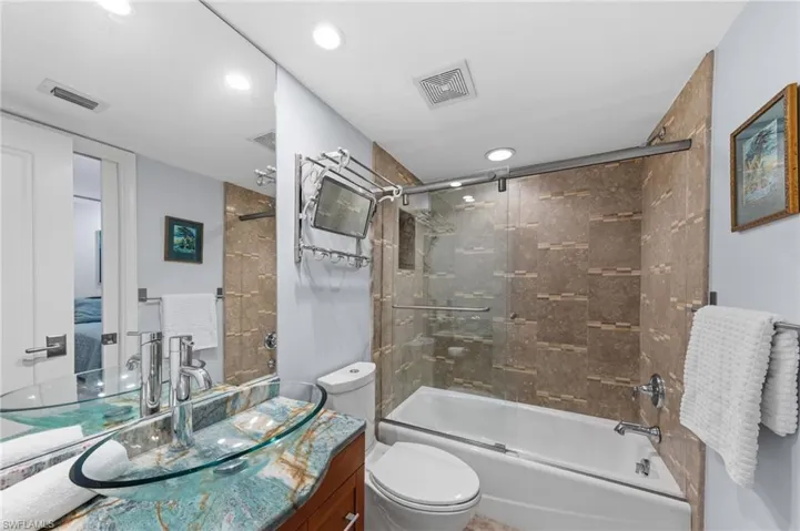 Full bath featuring vanity and shower / bath combination with glass door