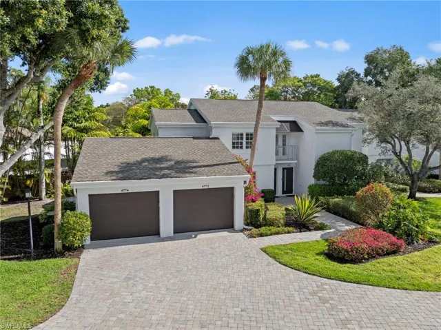 View of front of home featuring an attached garage, decorative driveway, stucco siding, and roof with shingles
