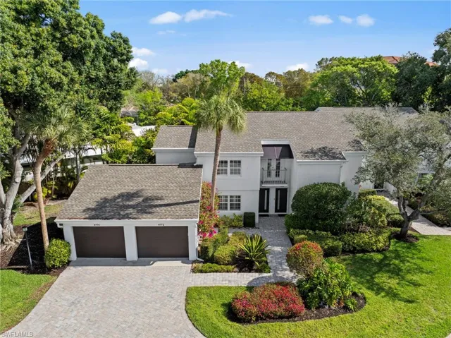 View of front of property featuring roof with shingles, a garage, driveway, a front yard, and french doors