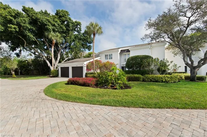 View of front of home with a front yard, driveway, stucco siding, and an attached garage