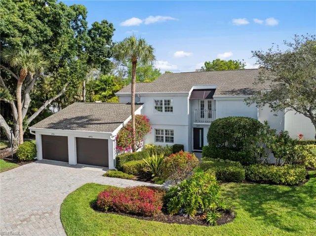 View of front of home with roof with shingles, decorative driveway, an attached garage, and a balcony