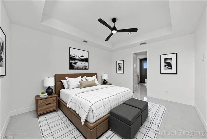Bedroom featuring a raised ceiling, a ceiling fan, and light tile patterned flooring