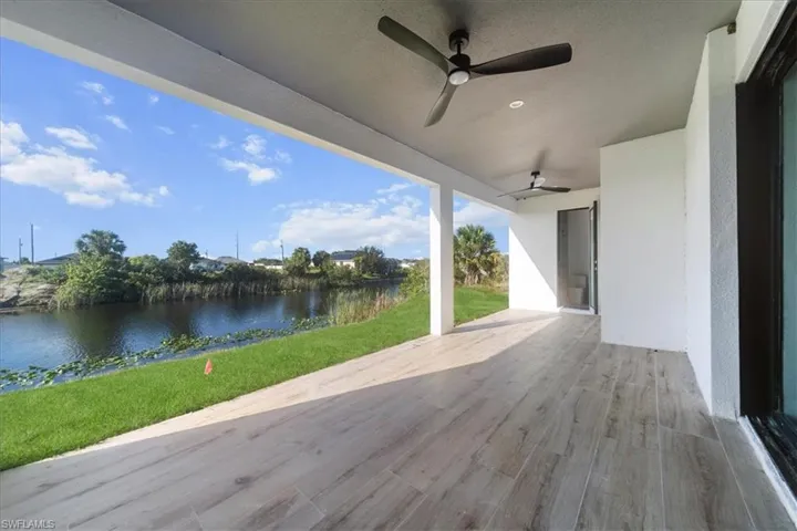 View of patio with a water view and ceiling fan