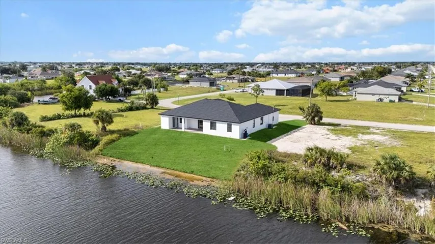Aerial view of residential area featuring a nearby body of water