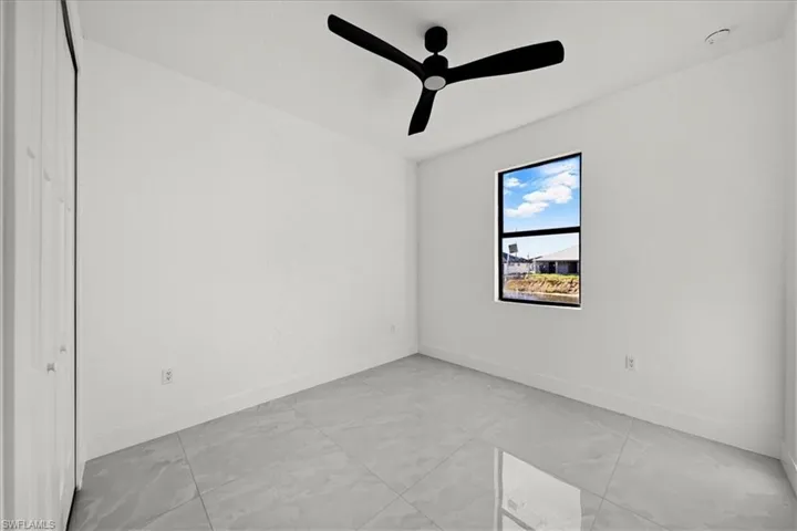 Unfurnished room with baseboards and a ceiling fan